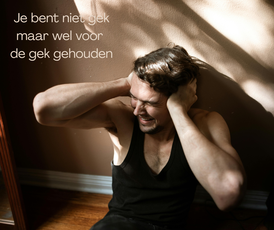 Een man zit tegen een muur met zijn handen op zijn hoofd, zichtbaar in een staat van stress of frustratie. Een tekstoverlay zegt: 'Je bent niet gek maar wel voor de gek gehouden.'